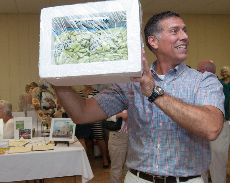 Rep. Stephen Smyk, R-Lewes/Milton, shows off the lima beans up for auction, they brought $200 a quart. BY DENY HOWETH